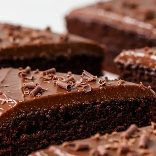 Des parts de chocolat en poudre gateau, généreusement nappées d'un glaçage au chocolat et décorées de copeaux de chocolat. Un dessert irrésistible.