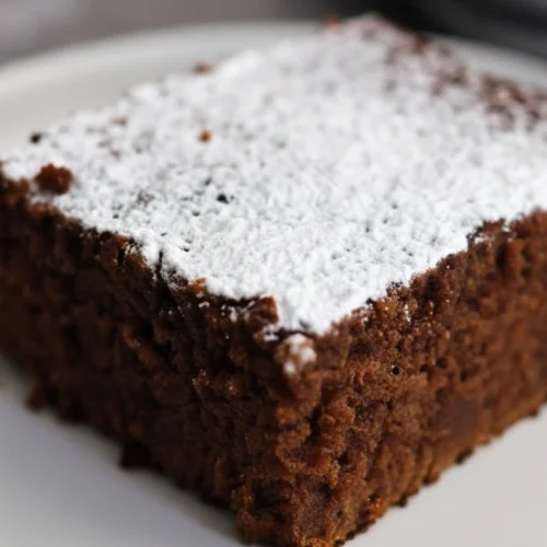 Délicieuse part de gâteau au Nesquik, moelleuse et saupoudrée d'un voile de sucre glace. Un dessert réconfortant et parfait pour le goûter.