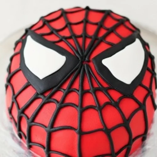 Un magnifique gâteau Spiderman : Vue rapprochée d'un gâteau rond et rouge représentant le visage de Spiderman, avec des toiles d'araignée noires et les yeux blancs distinctifs.