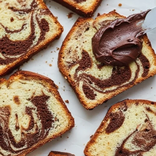 Vue de dessus alléchante de tranches de savane gateau marbré chocolat-vanille, dont l'une est généreusement nappée de crème au chocolat avec une spatule.