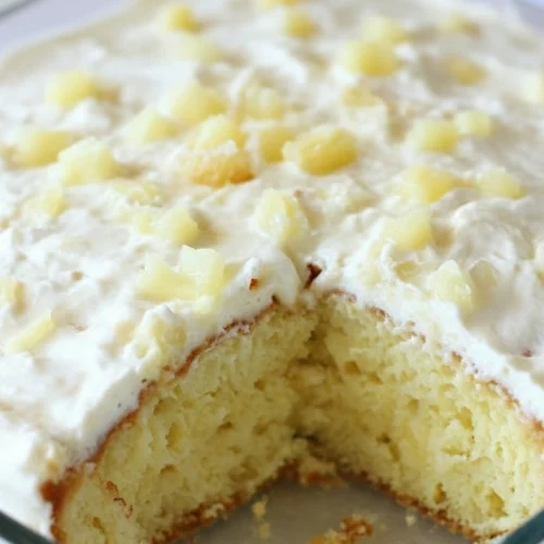 Un délicieux gâteau à l'ananas avec un glaçage crémeux et des morceaux d'ananas, une version appétissante de la recette gateau ananas.